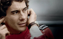 Man in red racing suit wearing a classic brown leather watch, close-up portrait