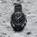 Men's black chronograph wristwatch with tachymeter bezel on textured moon surface background